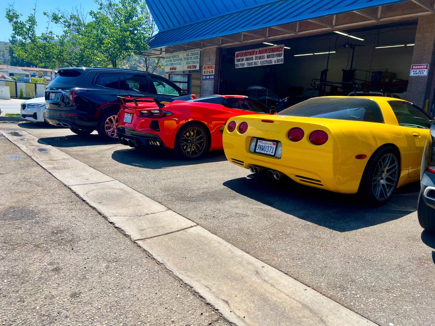 All Model Repair storefront with sports cars parked outside