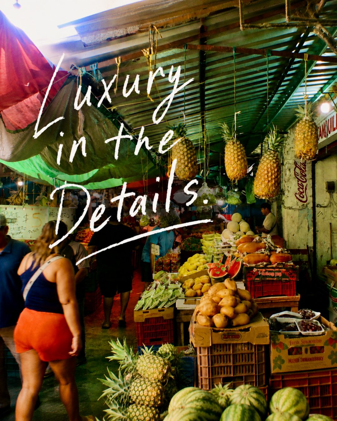 Luxury in the details — a vibrant market stall with hanging pineapples, MOW Impossible to Ignore